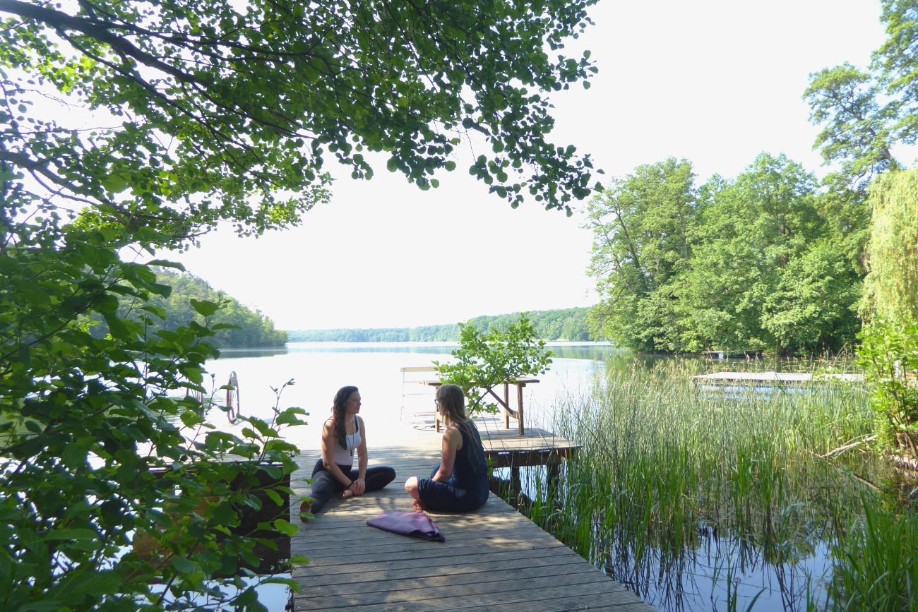 women sitting by a lake